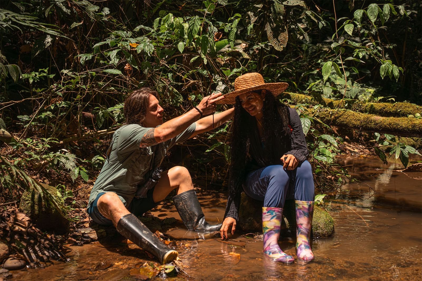 Pareja descansando en un riachuelo de agua clara