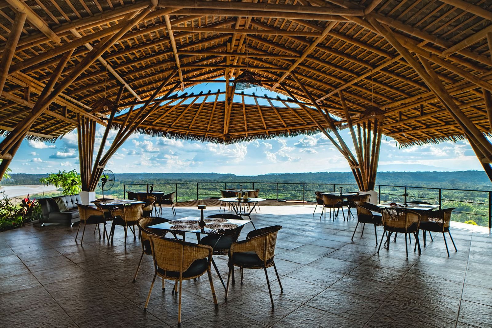 Restaurante bajo una gran cubierta de bambú, abierto a la selva y al río